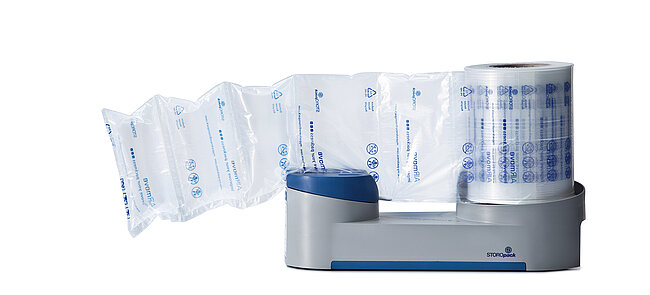 
			Eine kompakte graue Maschine befüllt Luftpolsterfolie mit Luft