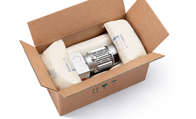 A cardboard box containing an engine component and foam packaging