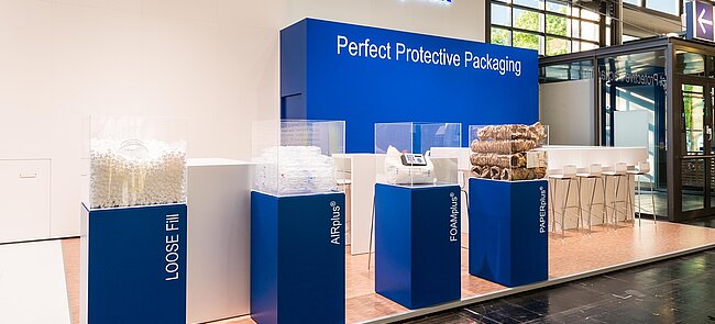 
			A Storopack trade fair stand with four blue display cases