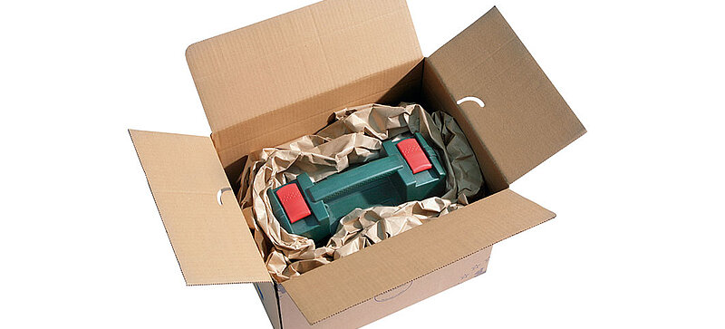 
		  A cardboard box containing a toolbox and brown paper cushioni