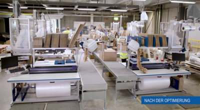 
				Abgebildet ist eine Halle in der sich mehrere Luftpolsterrollen und Kartons befinden.