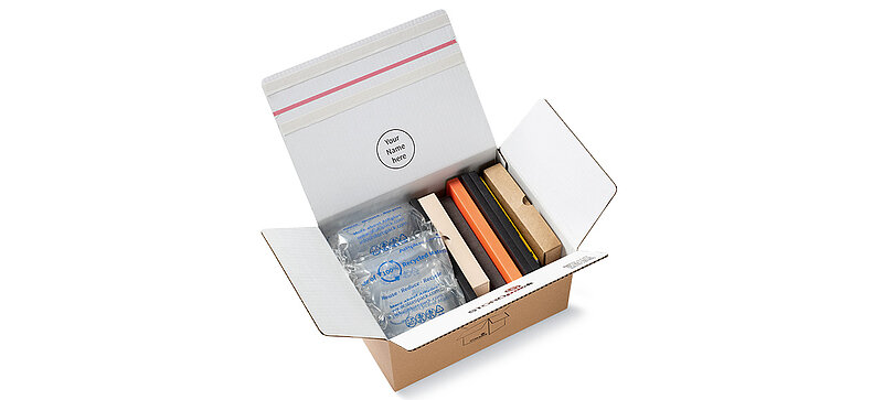 A cardboard box with colored boxes and 100% RECYCLED air cushions