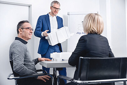 
			A man presenting an insulated box to two customers