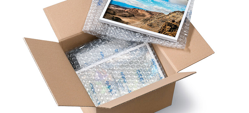 
		  A cardboard box containing a picture frame and air cushions