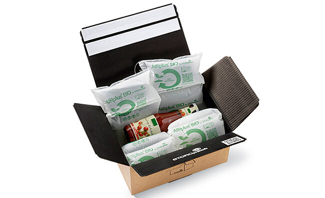 Open cardboard box with protective air cushions