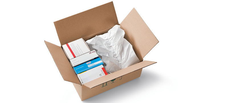A cardboard box containing medications and white paper cushioning