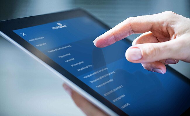 A tablet on which the Storopack website is open, and a hand